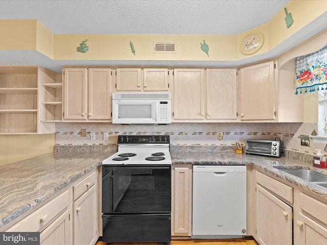 kitchen featuring decorative backsplash, light brown cabinets, light stone countertops, and white appliances