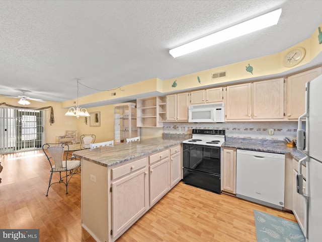 kitchen featuring ceiling fan with notable chandelier, white appliances, kitchen peninsula, and light hardwood / wood-style flooring