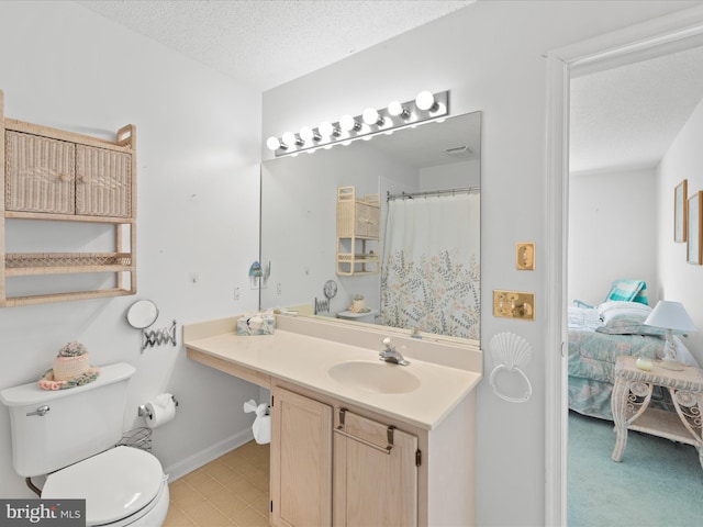 bathroom with vanity, toilet, and a textured ceiling