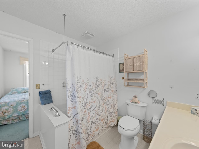 bathroom with vanity, toilet, and a textured ceiling