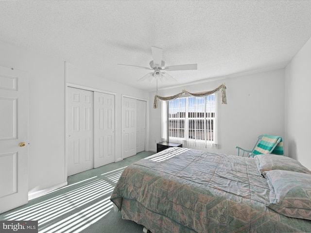 bedroom with ceiling fan, carpet, and a textured ceiling