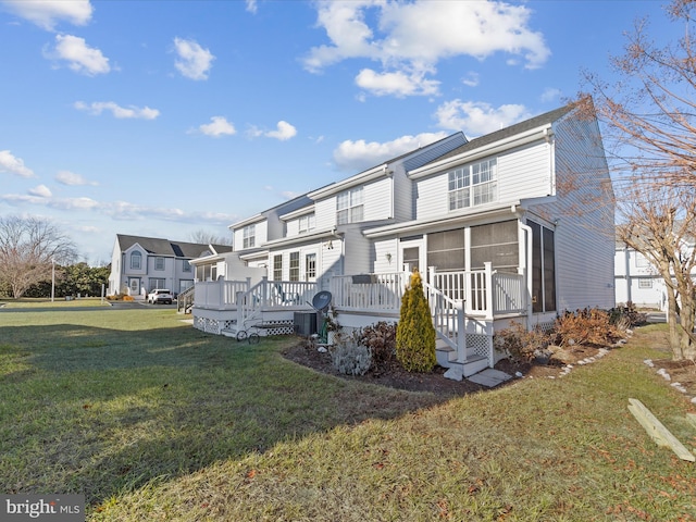 rear view of property featuring central AC unit, a deck, a lawn, and a sunroom