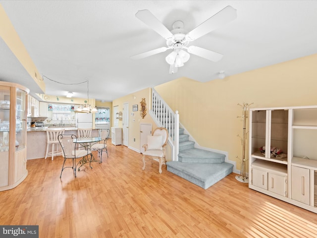 living room with ceiling fan, light hardwood / wood-style floors, and sink