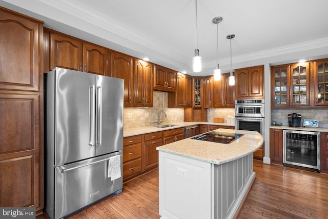 kitchen with sink, light stone counters, light wood-type flooring, appliances with stainless steel finishes, and beverage cooler