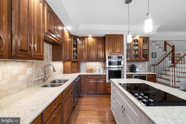 kitchen featuring stainless steel appliances, ornamental molding, sink, and light stone counters