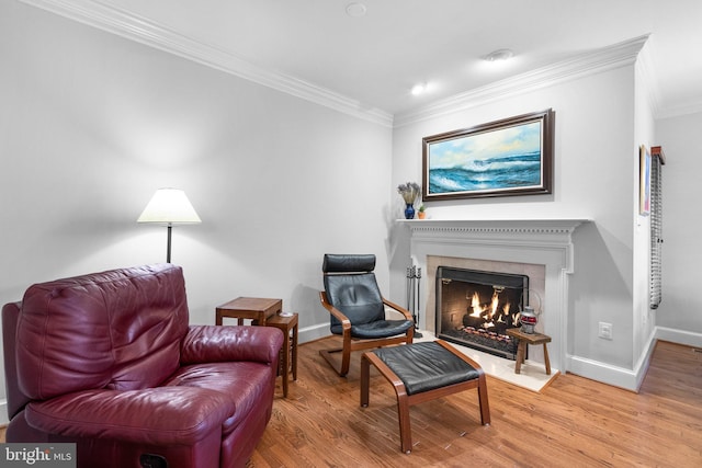 sitting room with crown molding and wood-type flooring