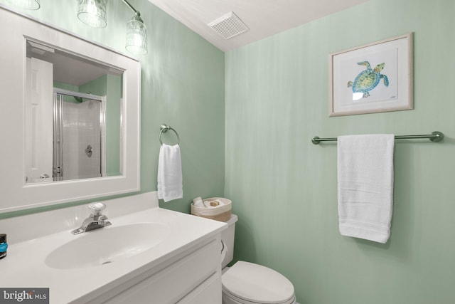 bathroom with vanity, toilet, and an enclosed shower