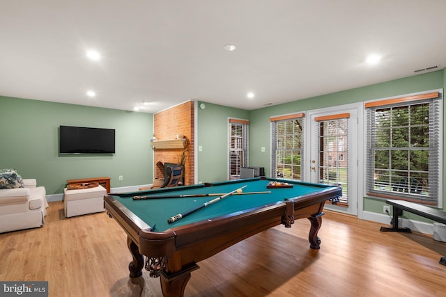 recreation room featuring billiards, a fireplace, and light hardwood / wood-style flooring