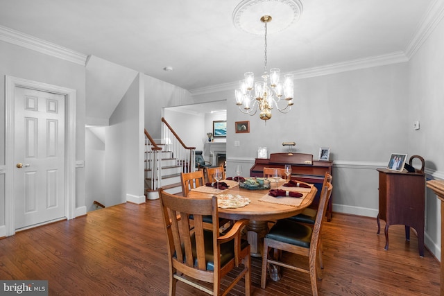 dining area with an inviting chandelier, crown molding, and dark hardwood / wood-style floors