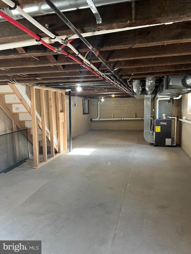 basement with electric panel and heating unit