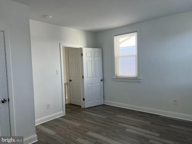 unfurnished bedroom with dark hardwood / wood-style flooring