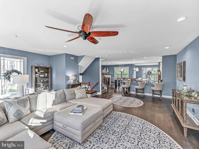 living room featuring ceiling fan, sink, and dark wood-type flooring