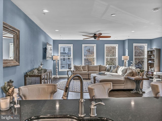 living room with hardwood / wood-style floors, ceiling fan, and sink