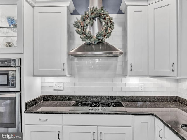 kitchen featuring white cabinetry, dark stone counters, and electric stovetop