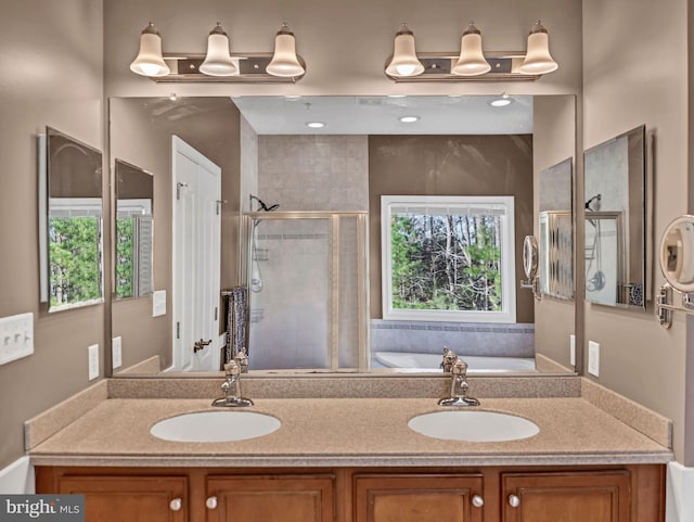 bathroom with vanity and shower with separate bathtub