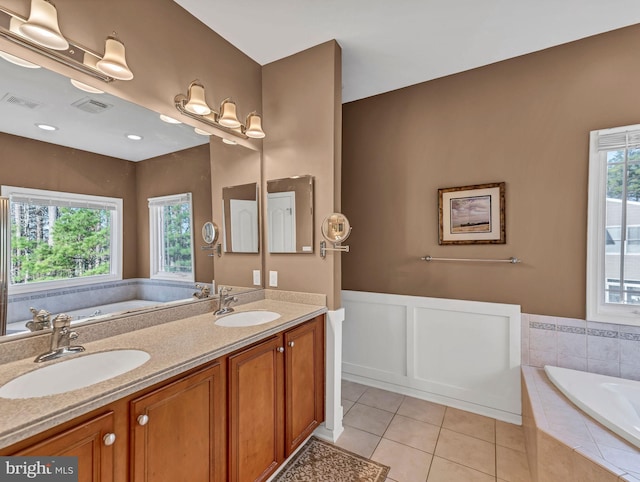 bathroom with vanity, a relaxing tiled tub, tile patterned floors, and plenty of natural light