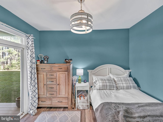 bedroom with a notable chandelier and light hardwood / wood-style flooring