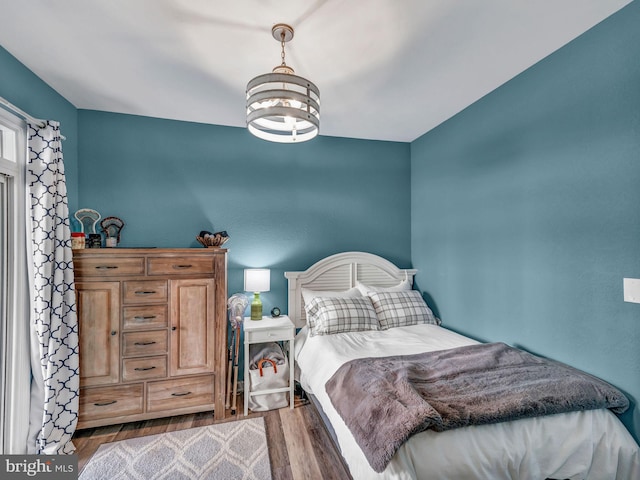 bedroom featuring hardwood / wood-style floors and a chandelier