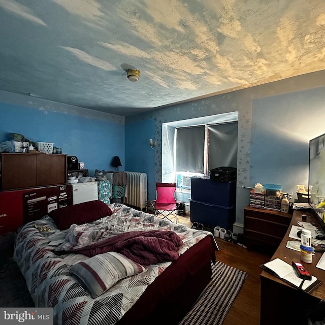 bedroom with wood-type flooring and radiator