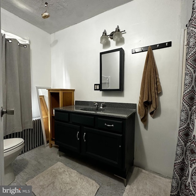 bathroom with vanity, a textured ceiling, and toilet