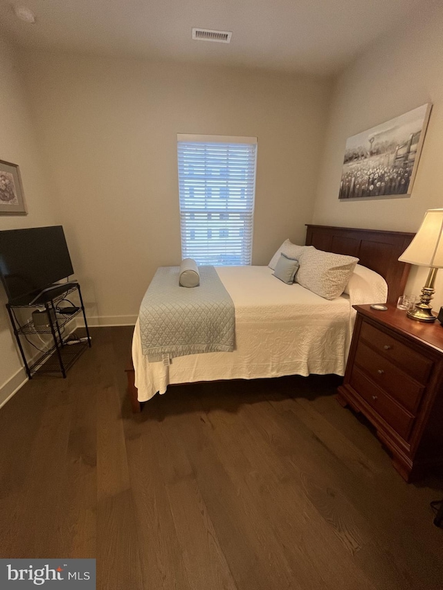 bedroom with dark hardwood / wood-style flooring