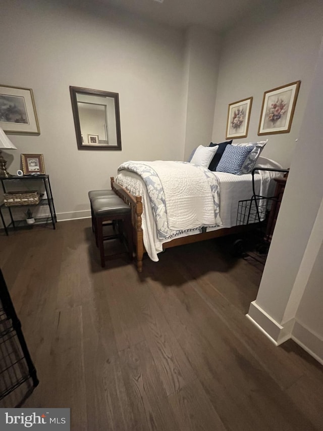 bedroom with dark hardwood / wood-style flooring