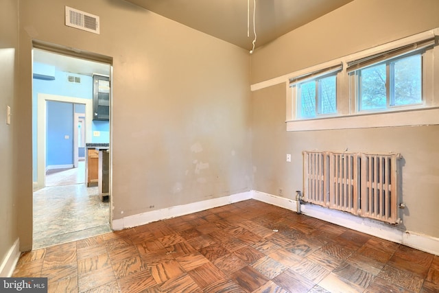 empty room with parquet floors and radiator