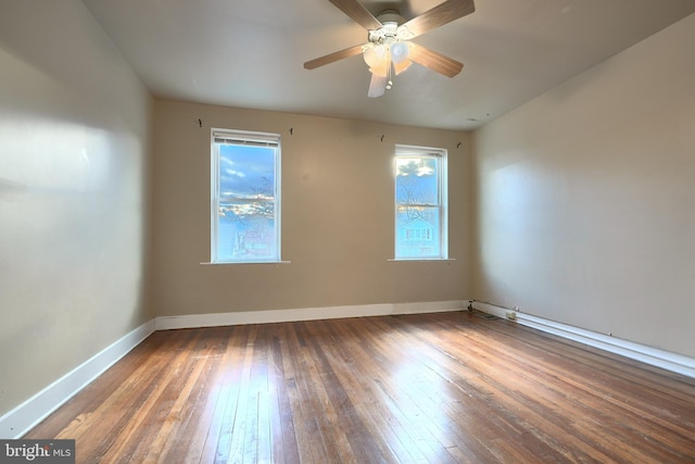 empty room featuring ceiling fan and dark hardwood / wood-style flooring