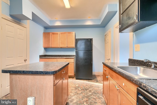 kitchen featuring dishwasher, a center island, sink, a tray ceiling, and black refrigerator