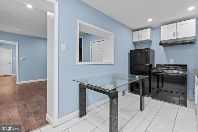 kitchen featuring white cabinetry, black appliances, and light hardwood / wood-style floors