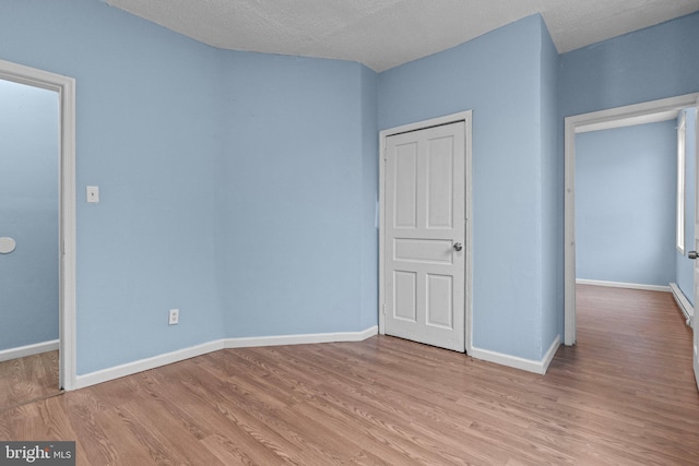 unfurnished bedroom featuring a textured ceiling and light hardwood / wood-style flooring