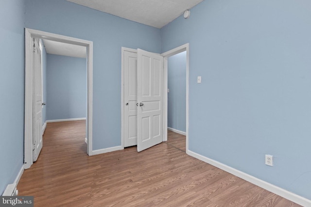 unfurnished bedroom with a textured ceiling and light wood-type flooring