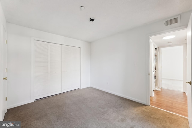 unfurnished bedroom featuring carpet and a closet