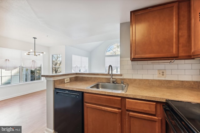 kitchen with black appliances, plenty of natural light, light hardwood / wood-style floors, and sink