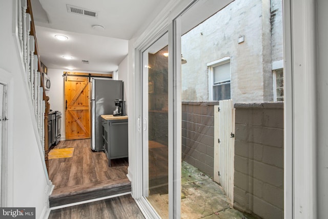 interior space featuring a barn door, dark hardwood / wood-style floors, and tile walls