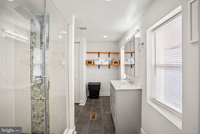 bathroom featuring tile patterned floors, vanity, and a shower with door