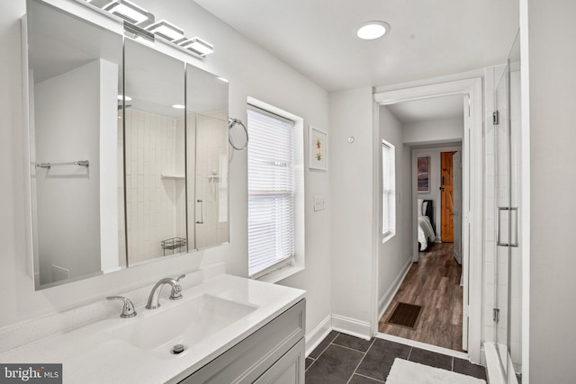 bathroom featuring vanity, wood-type flooring, and tiled shower