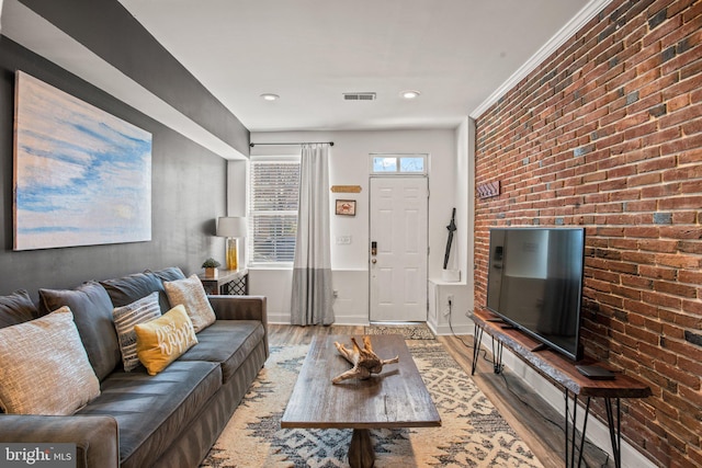 living room featuring light wood-type flooring and brick wall