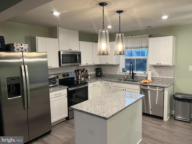 kitchen featuring a center island, white cabinets, stainless steel appliances, and sink