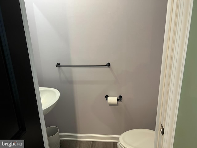 bathroom with wood-type flooring, toilet, and sink