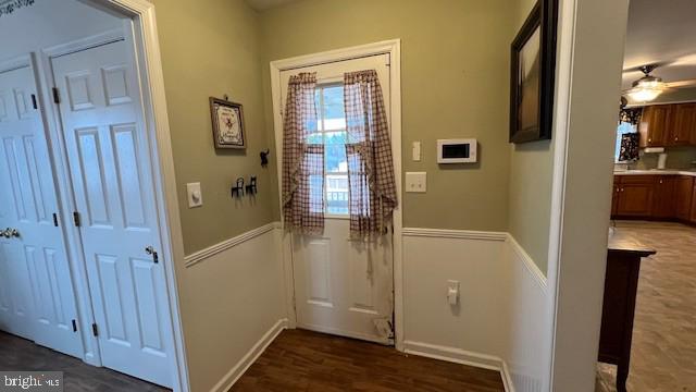 doorway featuring dark wood-type flooring and ceiling fan