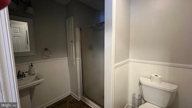 bathroom featuring toilet, tile patterned flooring, and walk in shower