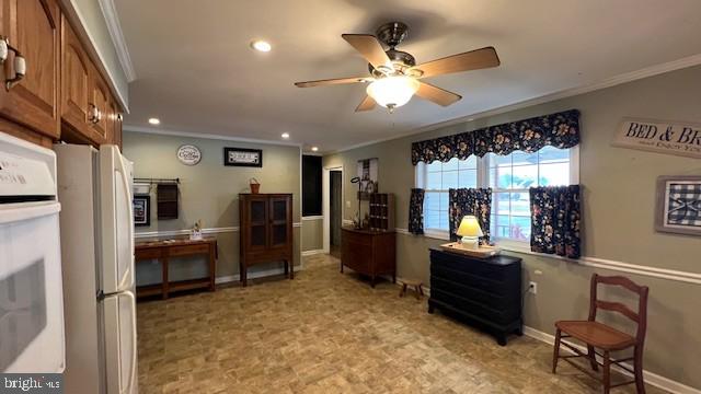 interior space with ceiling fan, ornamental molding, and white appliances