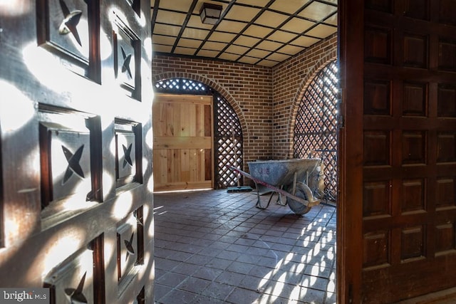 entrance foyer featuring brick wall