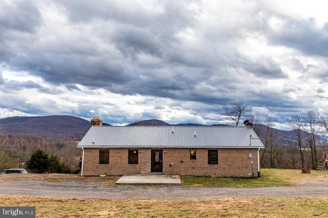 2520 Ridge Rd, Upper Tract, WV 26866 - rear view of house with a mountain view, a metal roof, brick siding, and a chimney