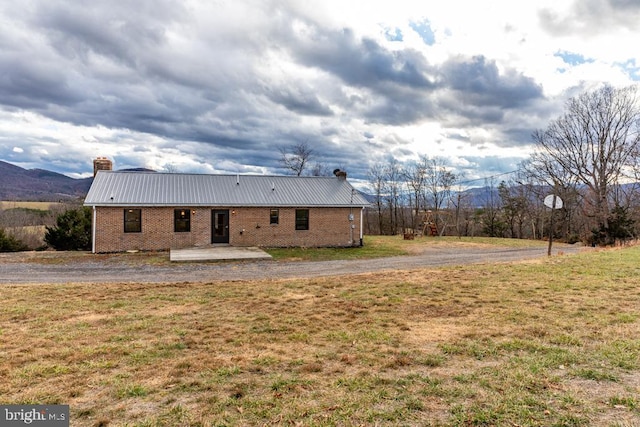 exterior space with a lawn and a mountain view