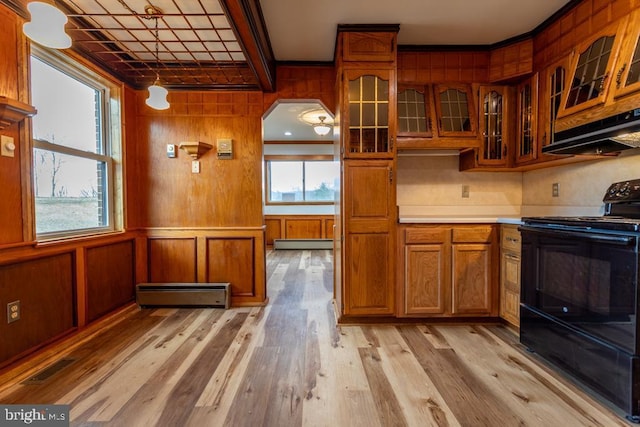 kitchen featuring exhaust hood, black range with electric stovetop, wooden walls, light wood-type flooring, and baseboard heating