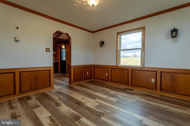 2520 Ridge Rd, Upper Tract, WV 26866 - empty room with a wainscoted wall, wood finished floors, crown molding, and arched walkways