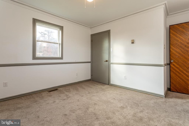 carpeted spare room featuring ornamental molding