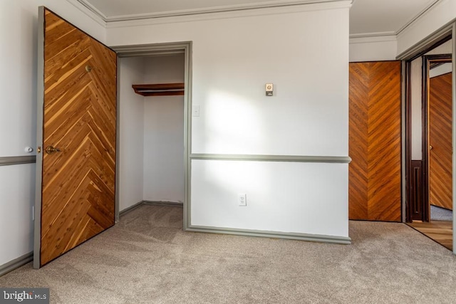 unfurnished bedroom featuring carpet flooring, a closet, and ornamental molding